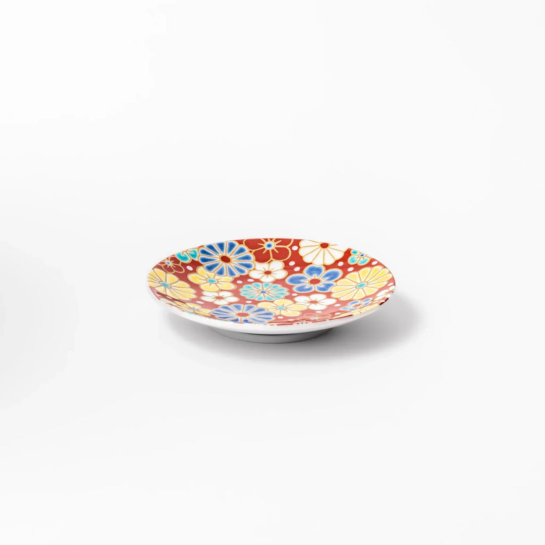 Round Japanese ceramic sauce dish with red background and plum and chrysanthemum motifs for condiments.