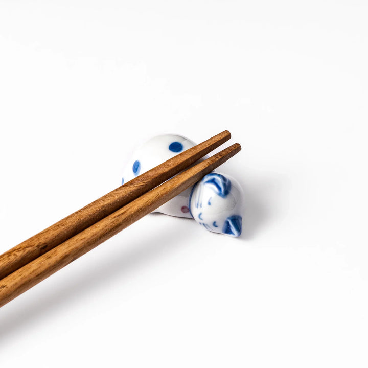 Blue polka dot cat-shaped ceramic chopstick rest with a relaxed expression, bringing a whimsical charm to your dining table.