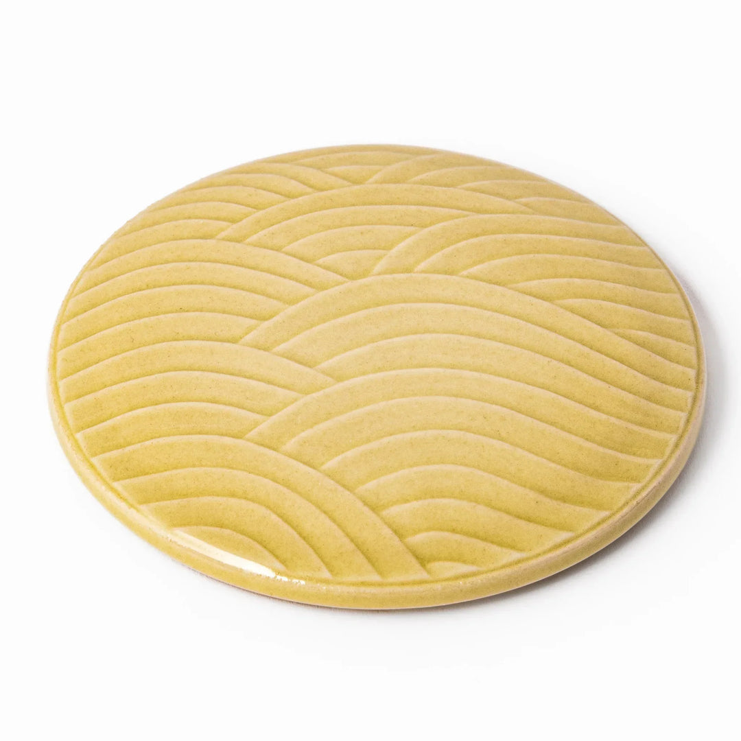 Yellow porcelain lid with embossed Seigaiha wave pattern, designed to fit stackable Japanese bowls with a modern touch.
