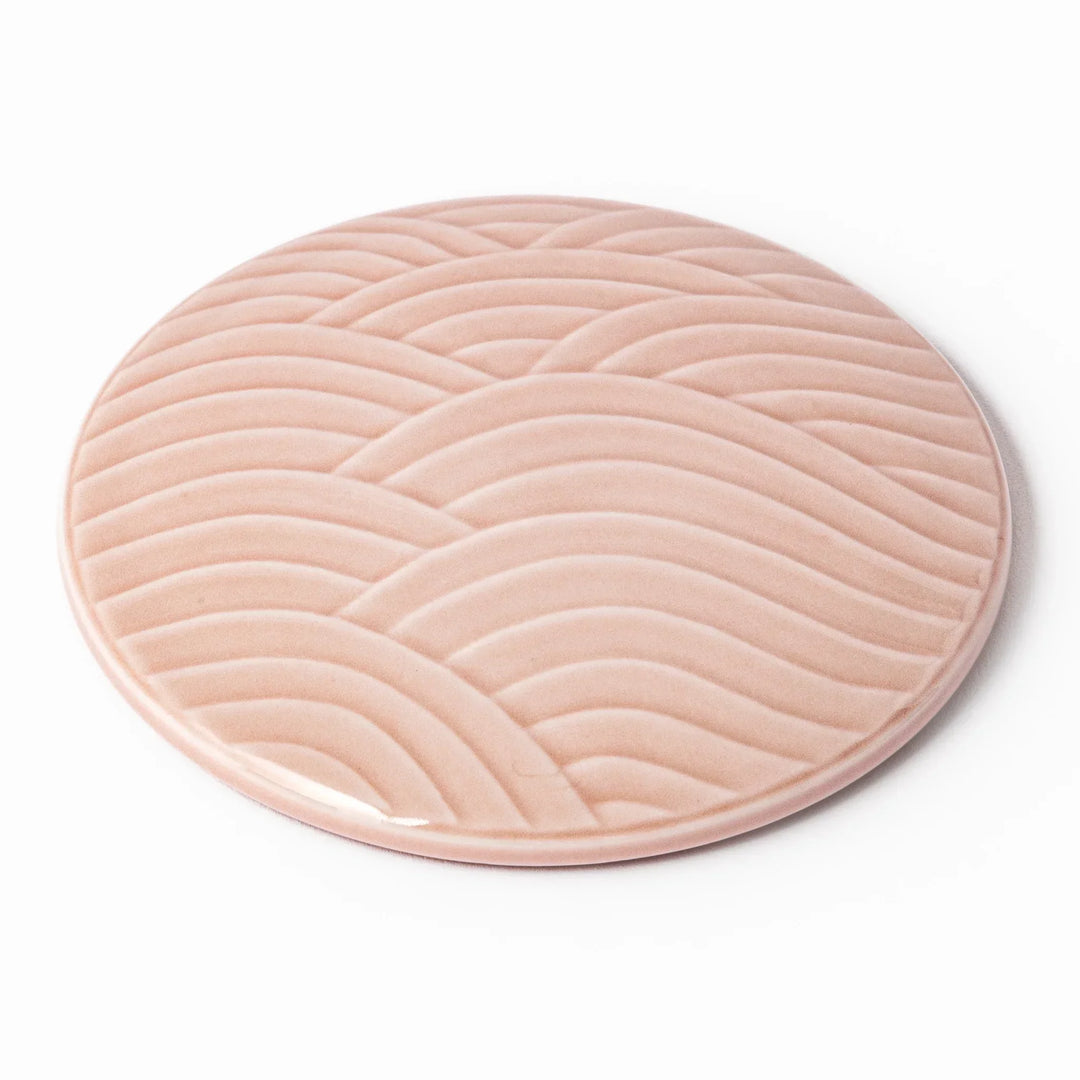 Soft pink porcelain lid with embossed Seigaiha wave design, crafted to pair with stackable Japanese bowls for elegant dining.