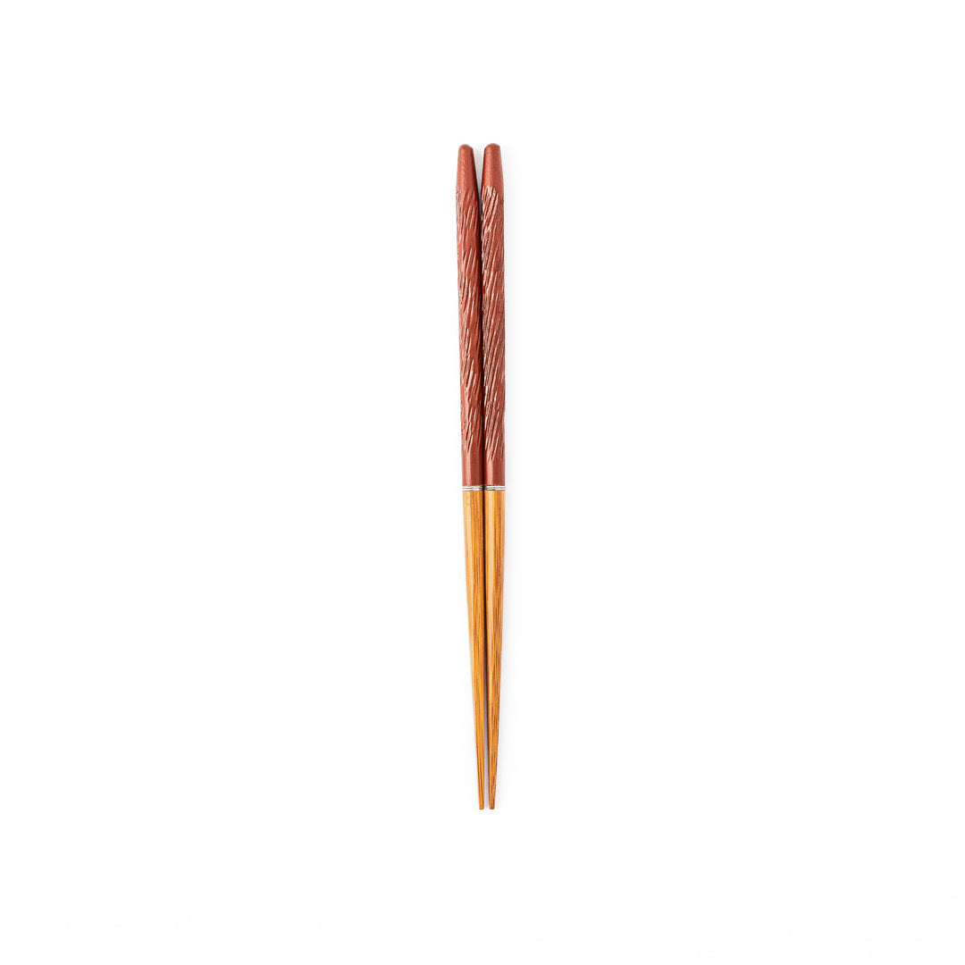 Portable Japanese travel chopsticks featuring a reddish brown textured handle with detailed carvings and a natural wood tip