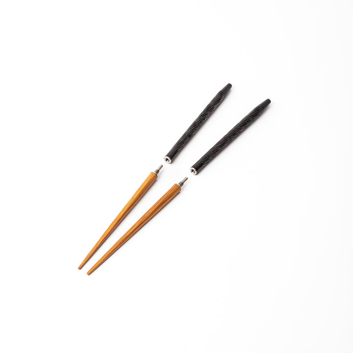 Black Japanese travel chopsticks unscrewed into two parts to demonstrate the portable design and durable metal joints