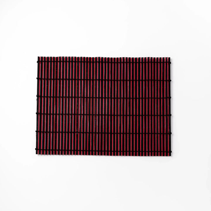 Red and black bamboo table mat with tight slats and black cords for bold modern Japanese table setting.