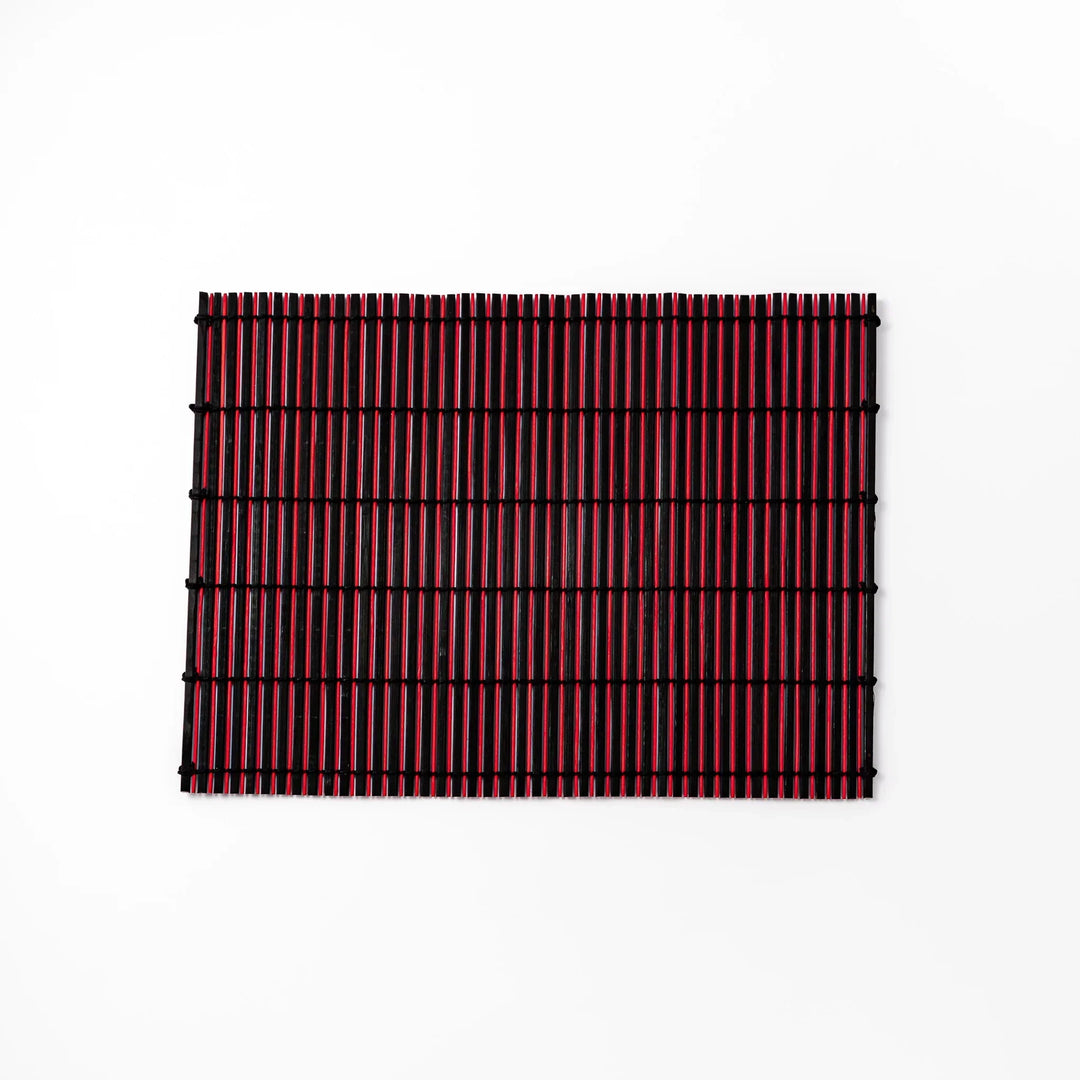Red and black bamboo table mat with tight slats and black cords for bold modern Japanese table setting.