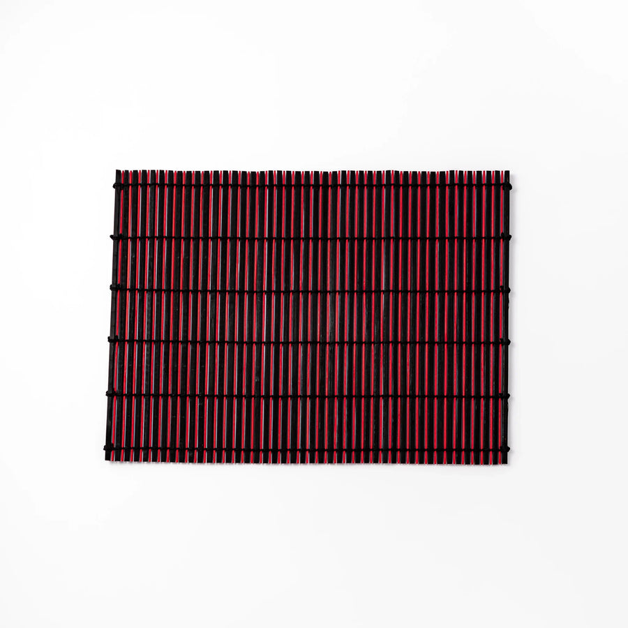 Red and black bamboo table mat with tight slats and black cords for bold modern Japanese table setting.