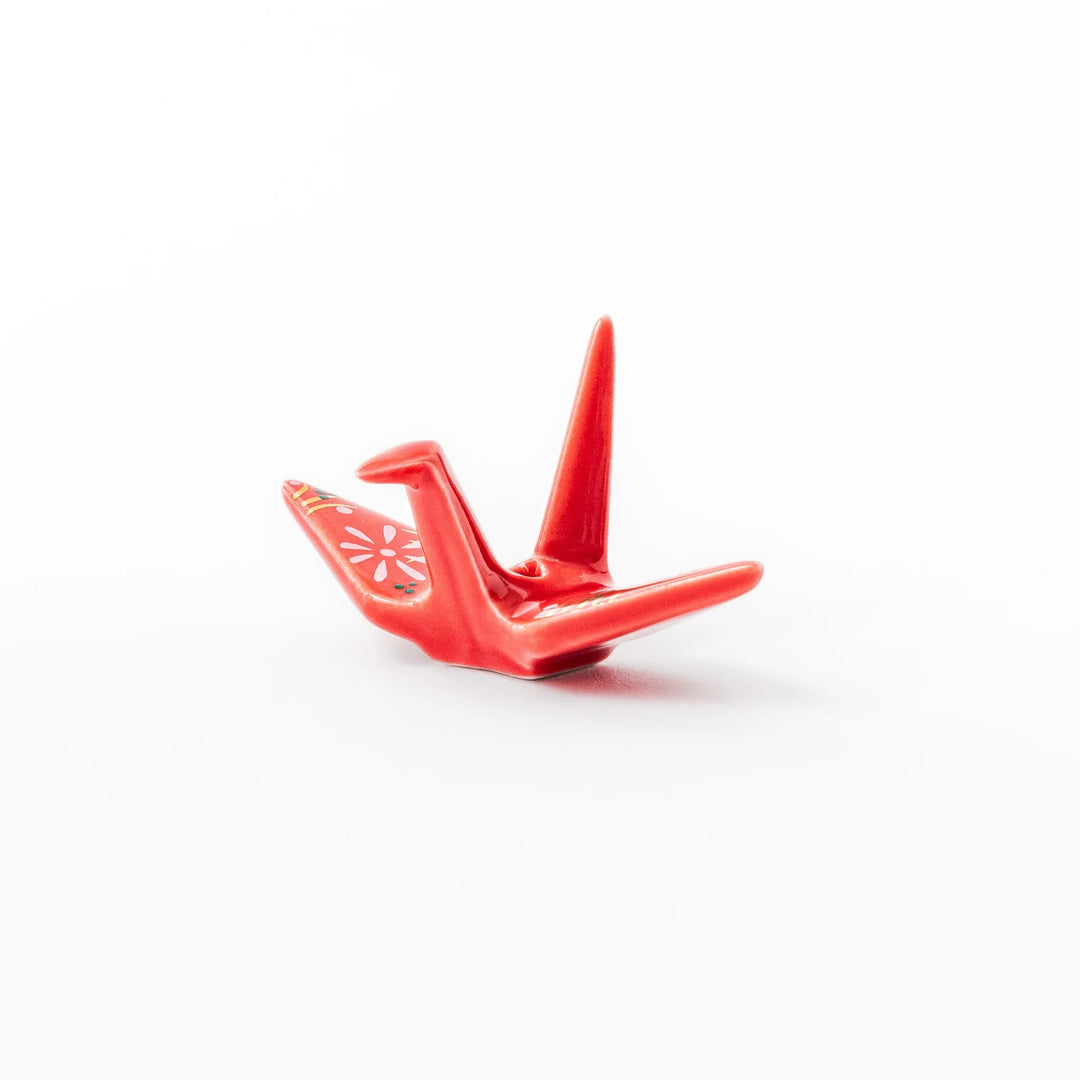 Red origami crane incense holder with floral details blending Japanese tradition and modern decorative design.
