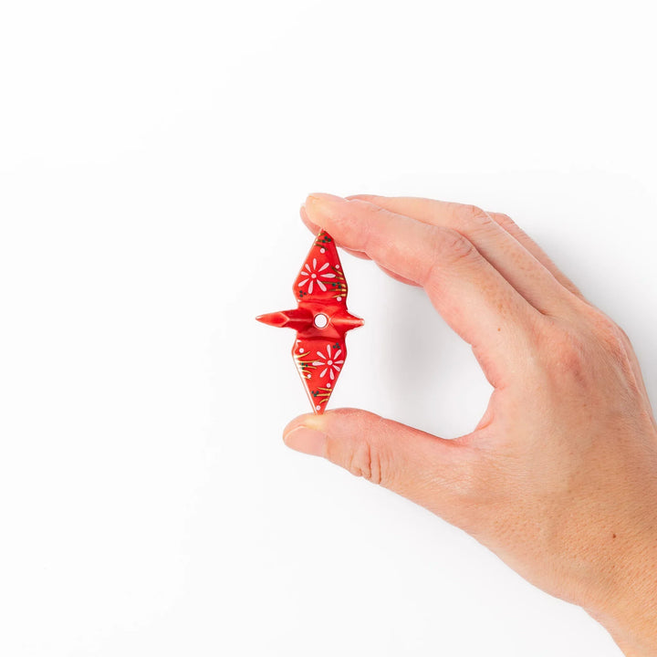 Red origami crane incense holder with floral details blending Japanese tradition and modern decorative design.