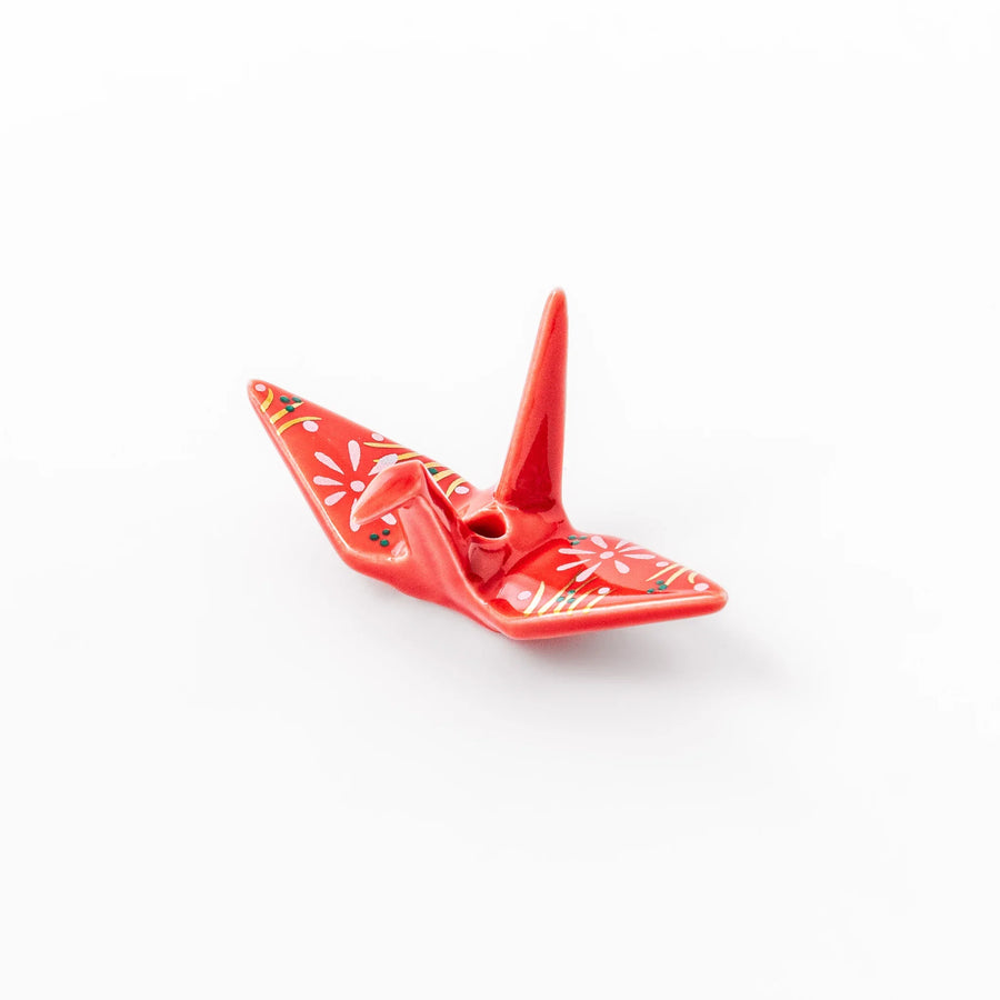 Red origami crane incense holder with floral details blending Japanese tradition and modern decorative design.
