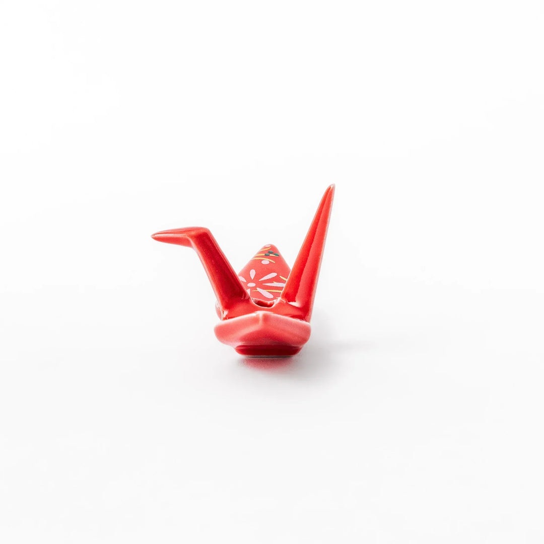 Red origami crane incense holder with floral details blending Japanese tradition and modern decorative design.