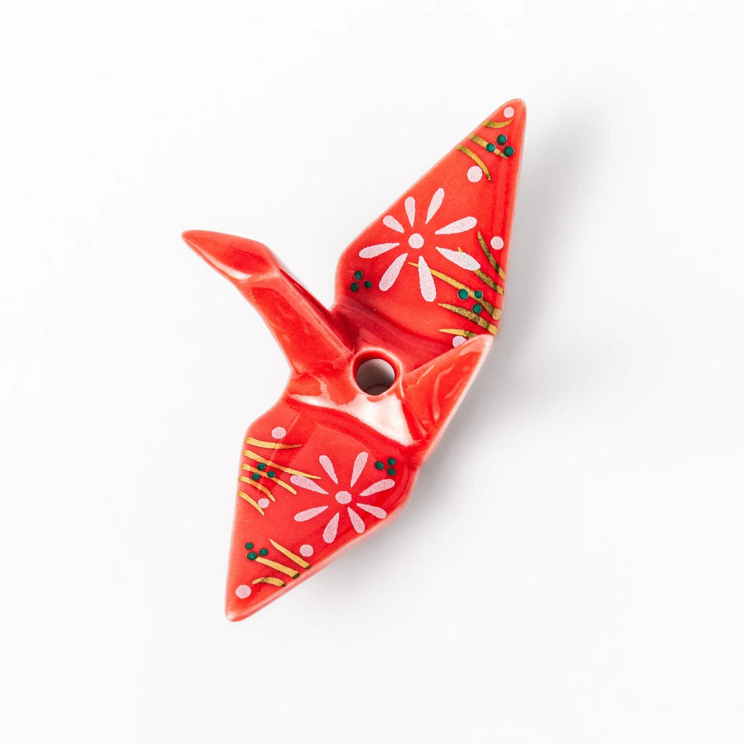 Red origami crane incense holder with floral details blending Japanese tradition and modern decorative design.