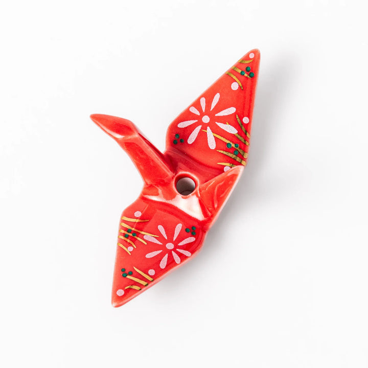 Red origami crane incense holder with floral details blending Japanese tradition and modern decorative design.