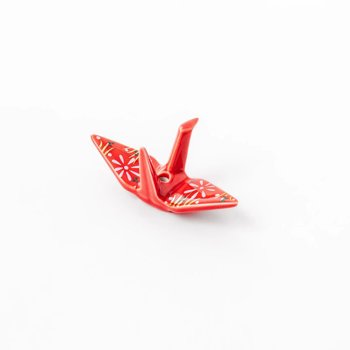 Red origami crane incense holder with floral details blending Japanese tradition and modern decorative design.