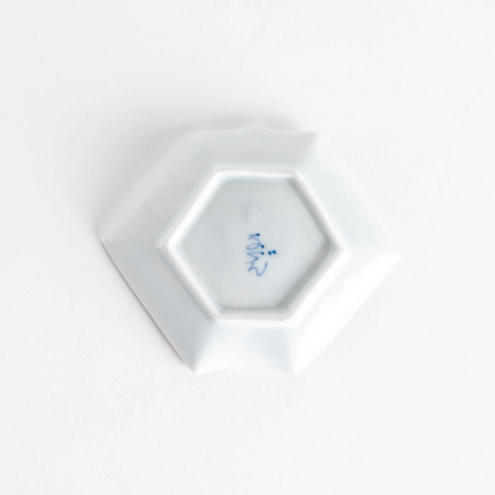 Bottom view of the Red Plum Origami Sauce Dish, showing the hexagonal base and a signature mark on the porcelain.
