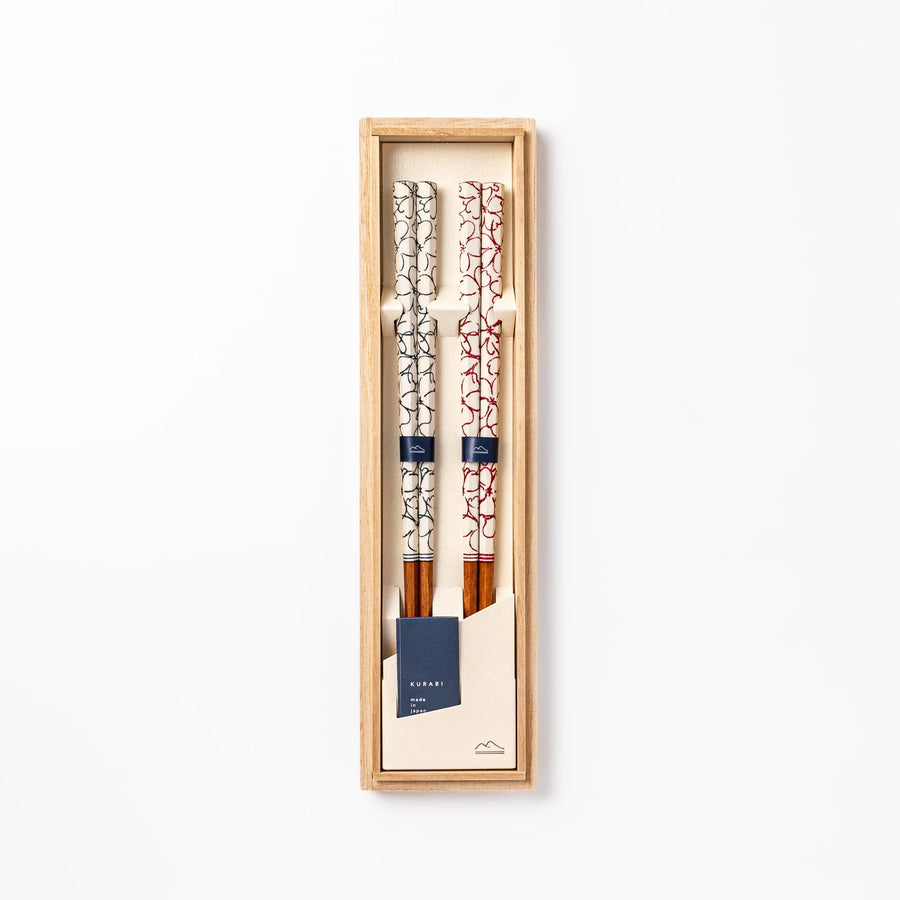 Red and blue Sakura Japanese chopsticks gift set with cherry blossom pattern handles in a wooden presentation box.