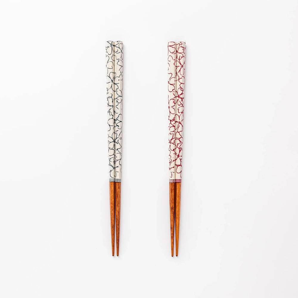 Red and blue Sakura Japanese chopsticks gift set with cherry blossom pattern handles in a wooden presentation box.