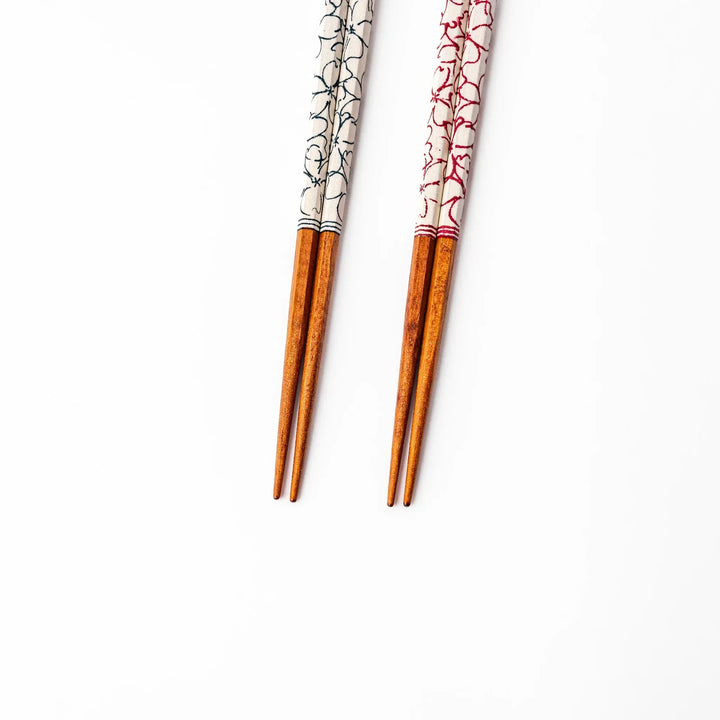 Red and blue Sakura Japanese chopsticks gift set with cherry blossom pattern handles in a wooden presentation box.