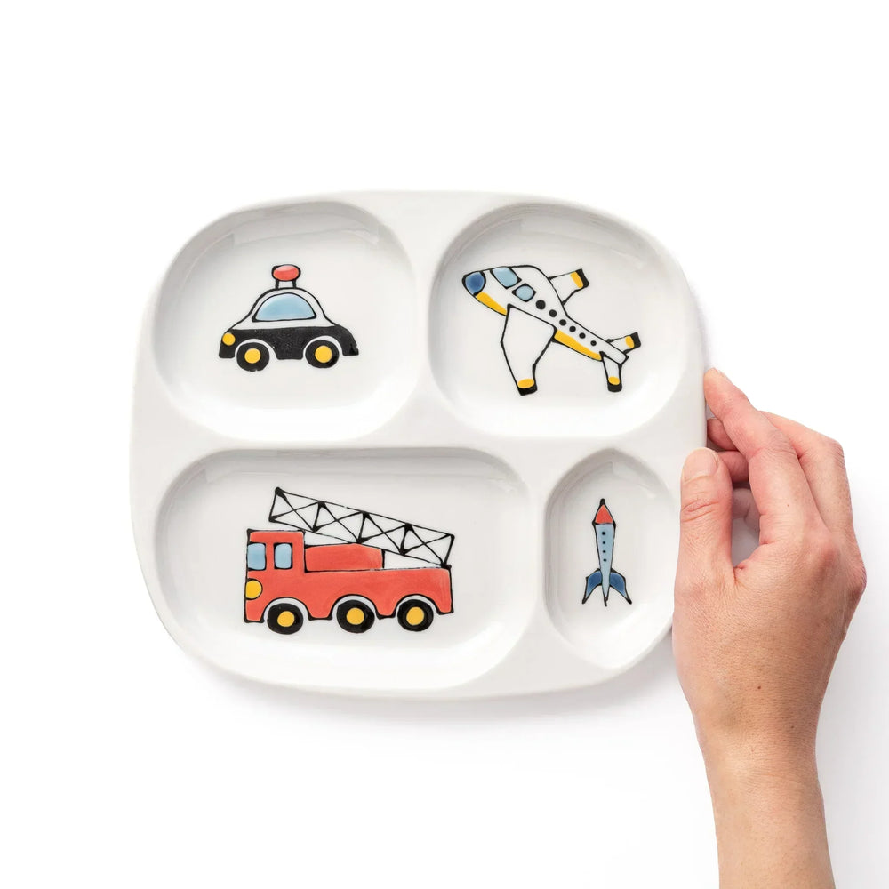 White ceramic kids plate with police car, airplane, fire truck, and rocket motifs in divided sections