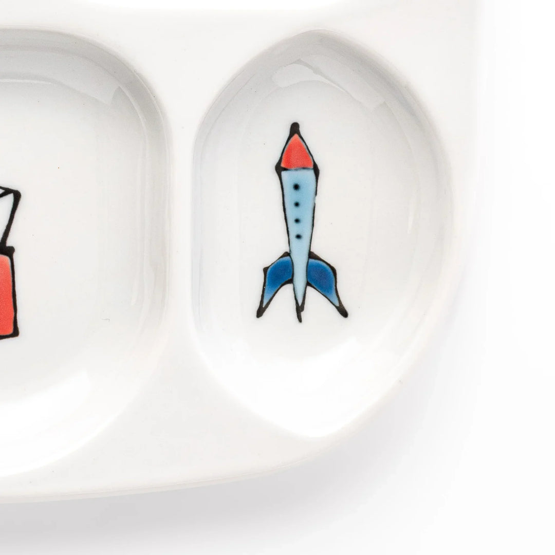 White ceramic kids plate with police car, airplane, fire truck, and rocket motifs in divided sections