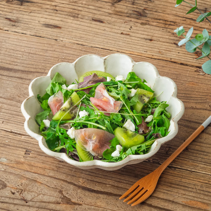 Rinka Petal Pasta Bowl filled with prosciutto kiwi salad served on a rustic wooden table with a wooden fork