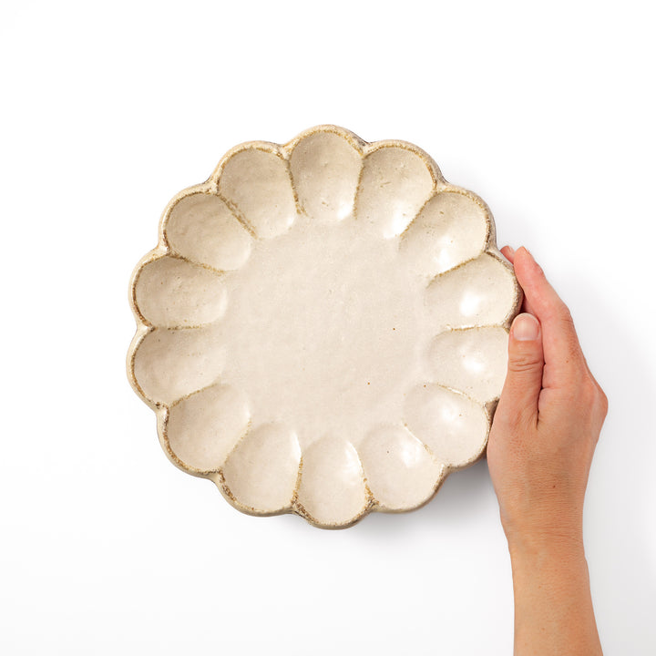 Medium Japanese Rinka ceramic petal salad plate in off white, seen from above, featuring a flower shaped rim