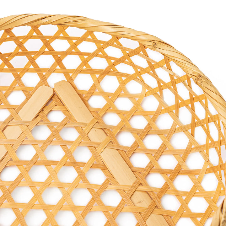 A medium round handwoven bamboo serving basket with a hexagonal mesh pattern lid resting on the woven border