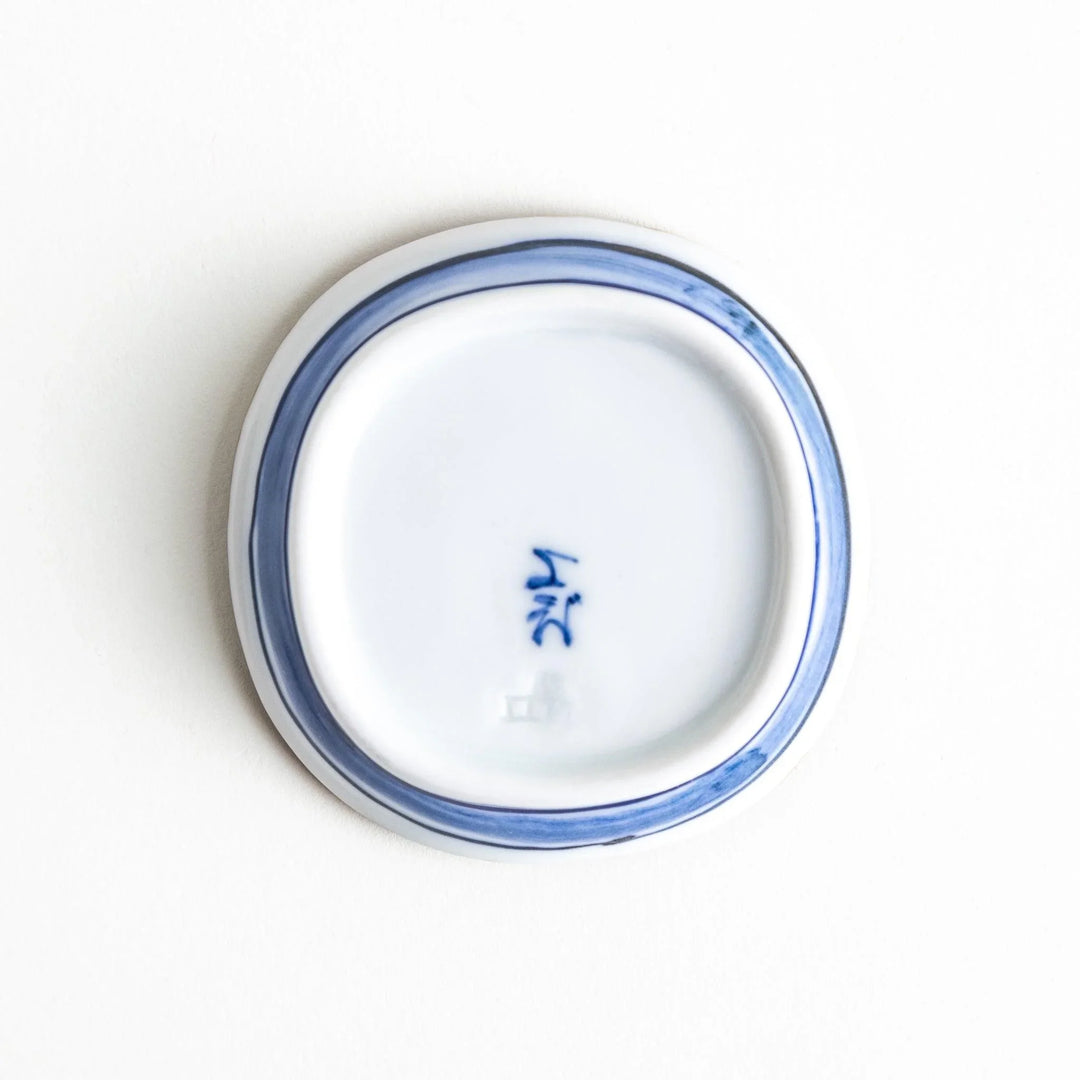 A round plate featuring a large, bold blue flower with a textured brown rim.