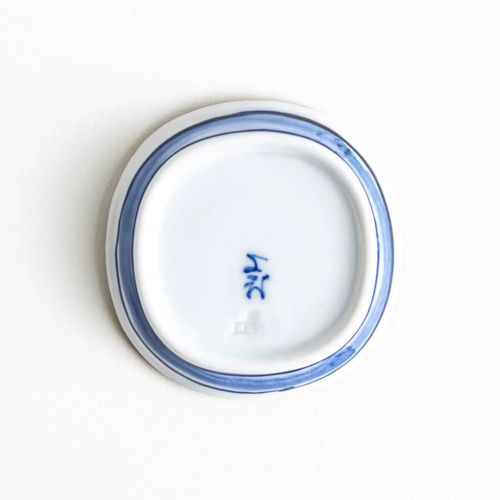 A round plate featuring a large, bold blue flower with a textured brown rim.