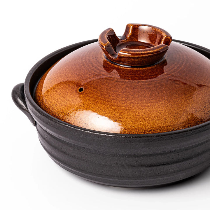 Japanese donabe clay pot with brown glazed lid and black base induction compatible for family hot pot.
