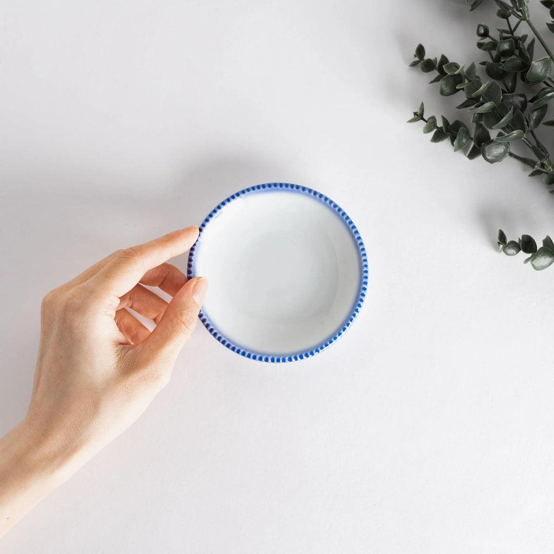A round white sauce dish with a rustic scallop-edged border. The border comes in blue, brown, and olive.