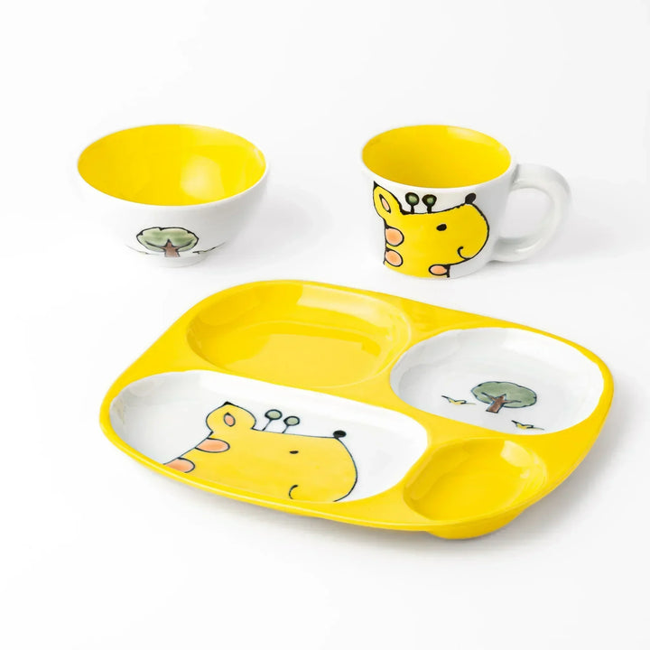 White ceramic kids’ mug with yellow giraffe and green ossicones, featuring a round handle and yellow interior.