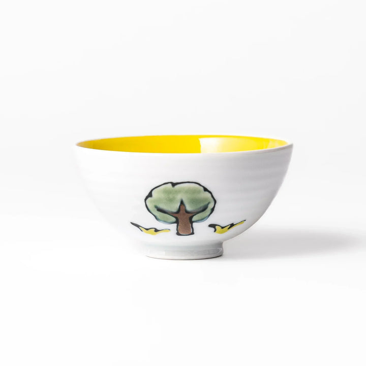 White ceramic kids rice bowl with smiling yellow giraffe illustration, vibrant yellow interior, round footed base