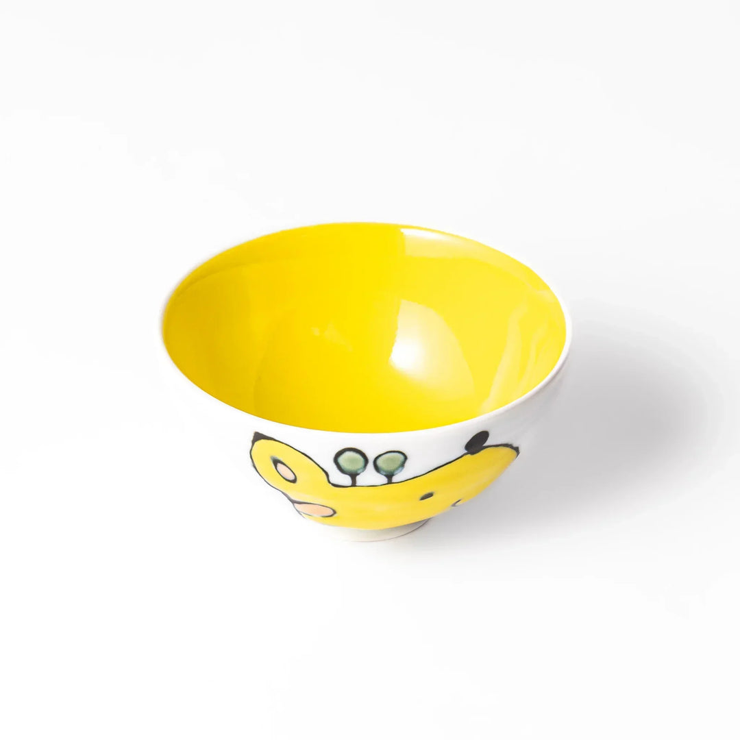 White ceramic kids rice bowl with smiling yellow giraffe illustration, vibrant yellow interior, round footed base