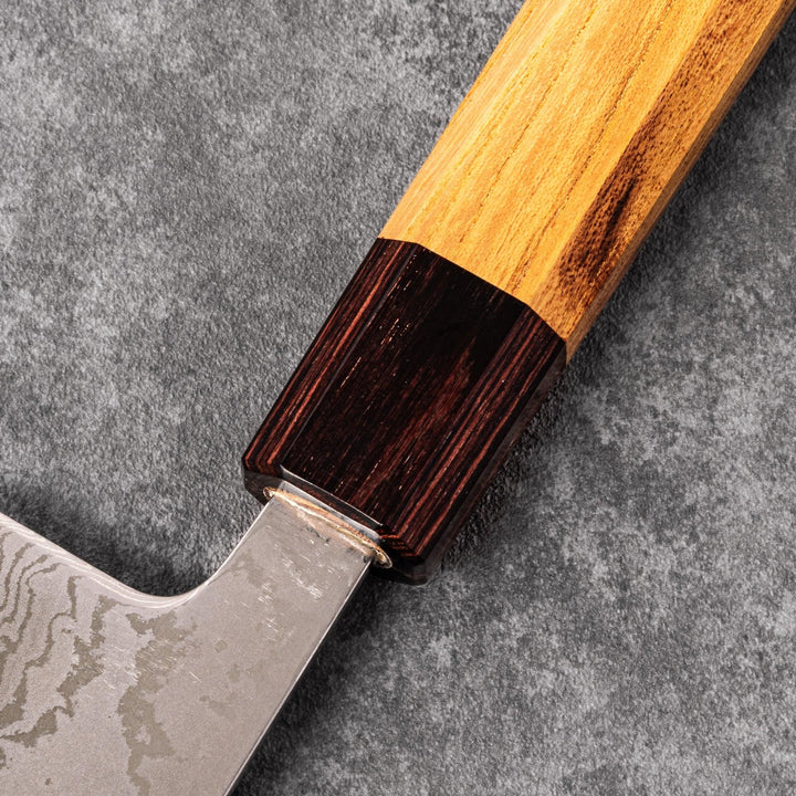 Japanese Damascus gyuto knife featuring a layered steel blade and natural wood handle displayed on gray stone background.