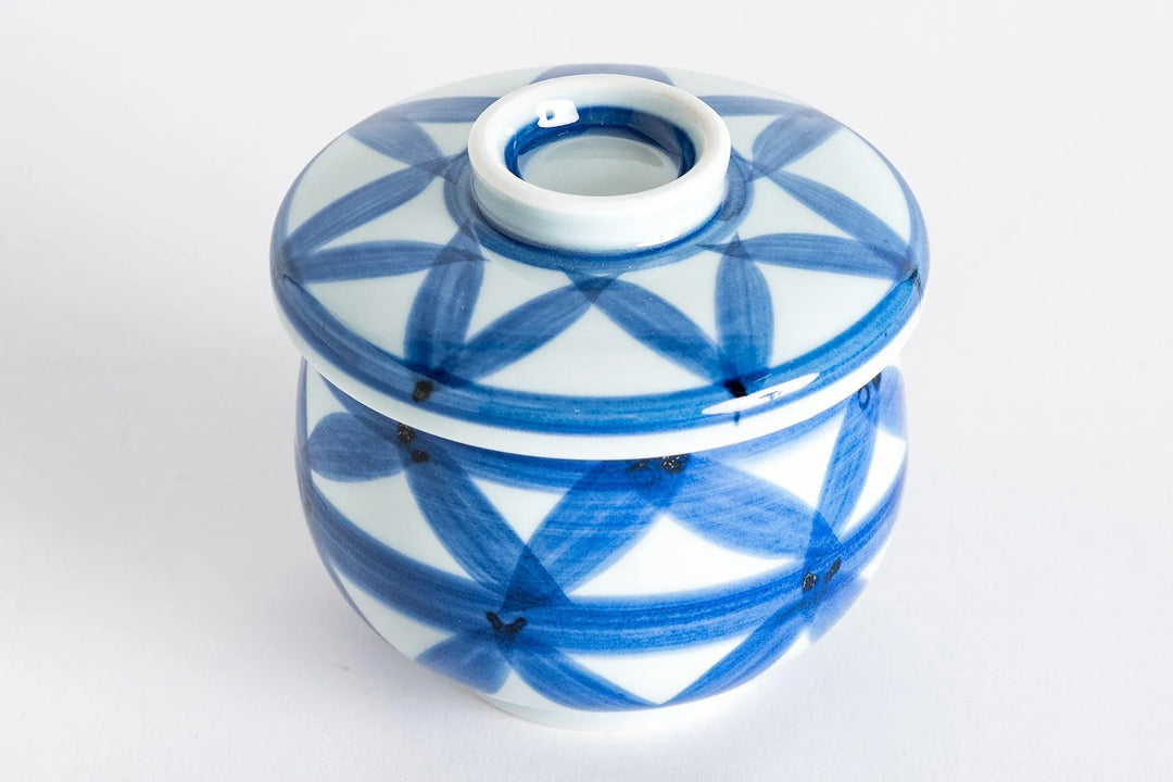 Blue porcelain chawanmushi bowl with hand painted basket weave pattern and fitted lid on a white background