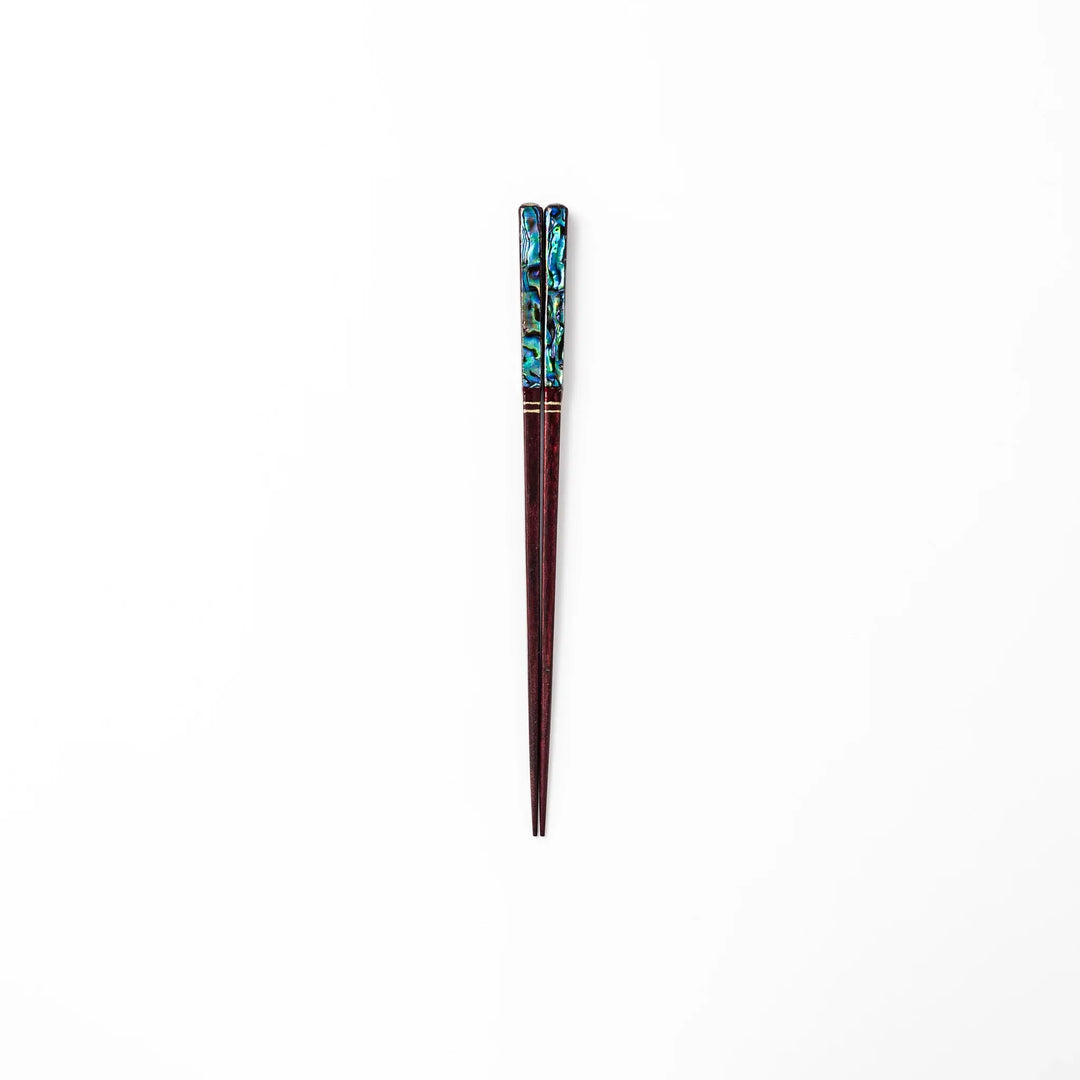 Japanese lacquer chopsticks with shimmering abalone shell inlay and deep red finish, handcrafted for elegant dining.