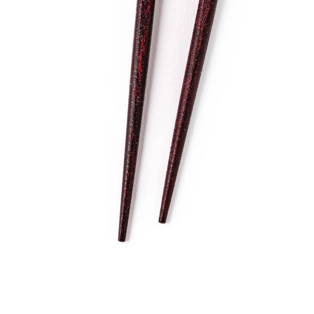 Japanese lacquer chopsticks with shimmering abalone shell inlay and deep red finish, handcrafted for elegant dining.