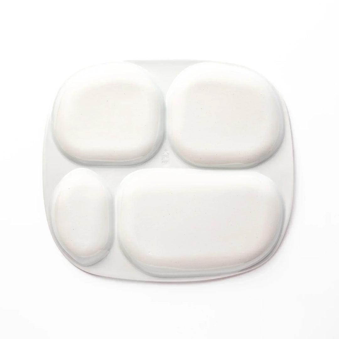 White ceramic kids plate with red, white and yellow Shinkansen train motifs in sections, accented by blue cloud details