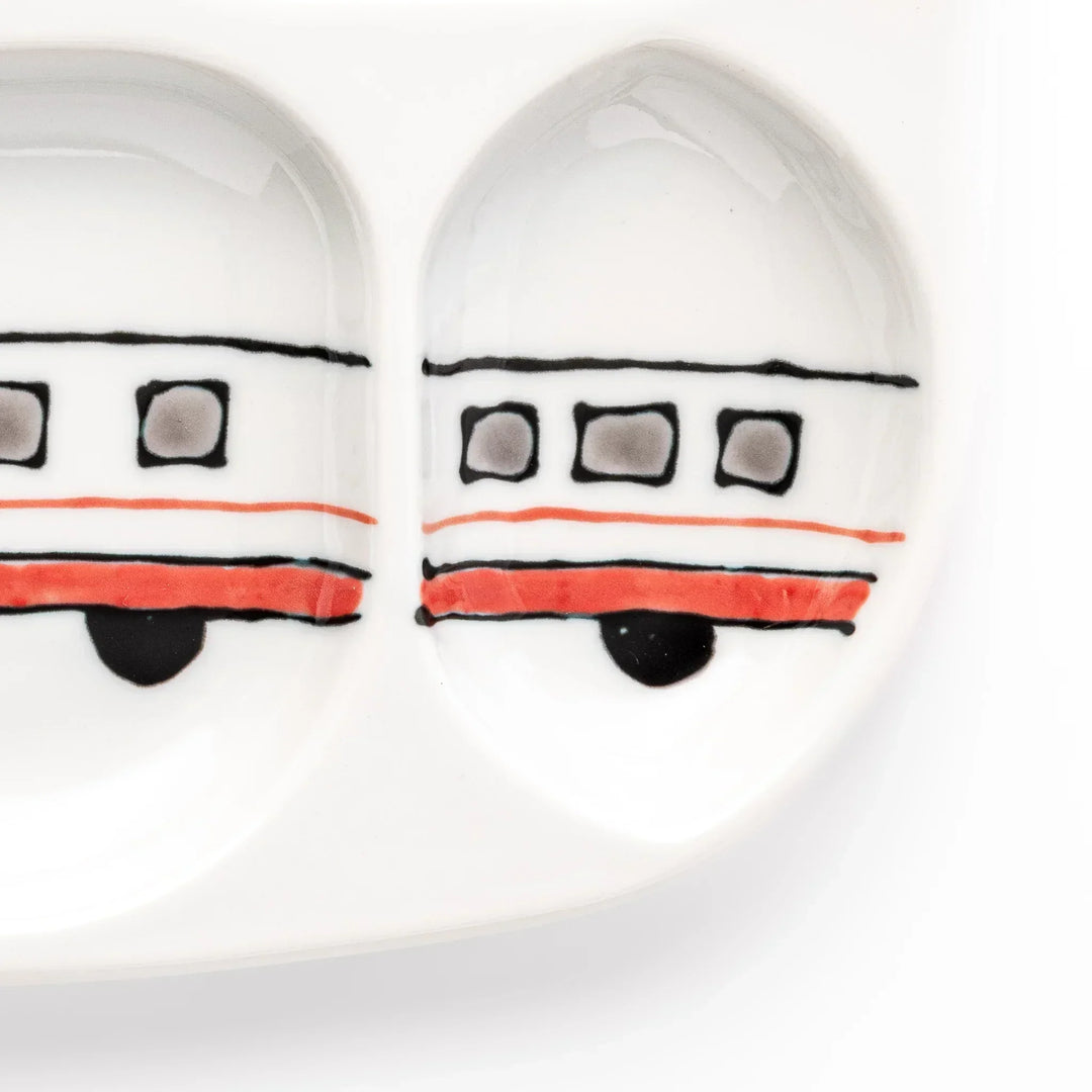 White ceramic kids plate with red, white and yellow Shinkansen train motifs in sections, accented by blue cloud details