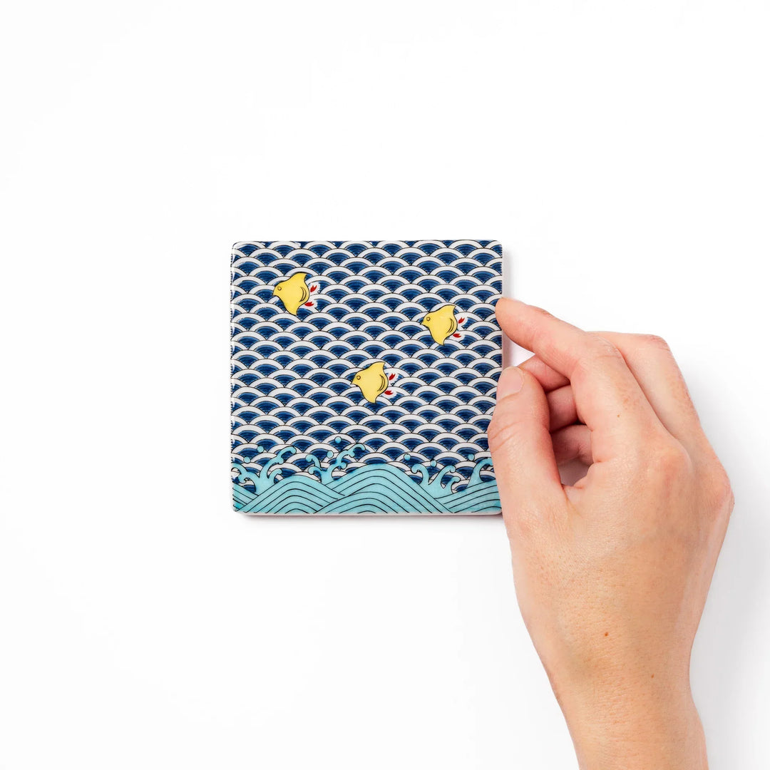 Square Japanese ceramic coaster with blue wave pattern and yellow shorebirds for artistic stylish dining.