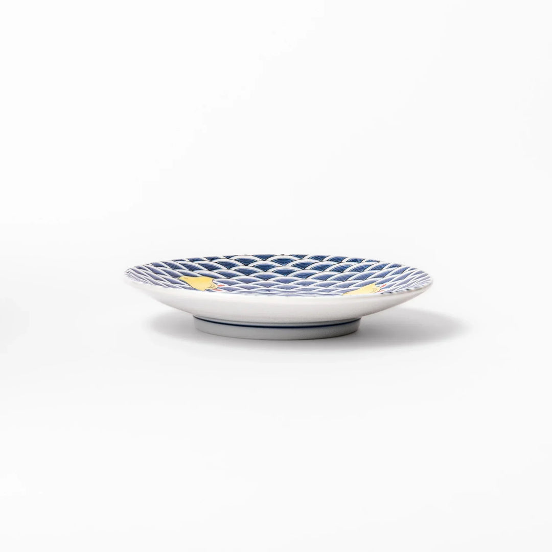 Round Japanese ceramic sauce dish with blue wave pattern and yellow shorebirds for soy sauce or condiments.