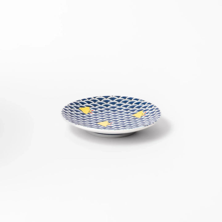 Round Japanese ceramic sauce dish with blue wave pattern and yellow shorebirds for soy sauce or condiments.