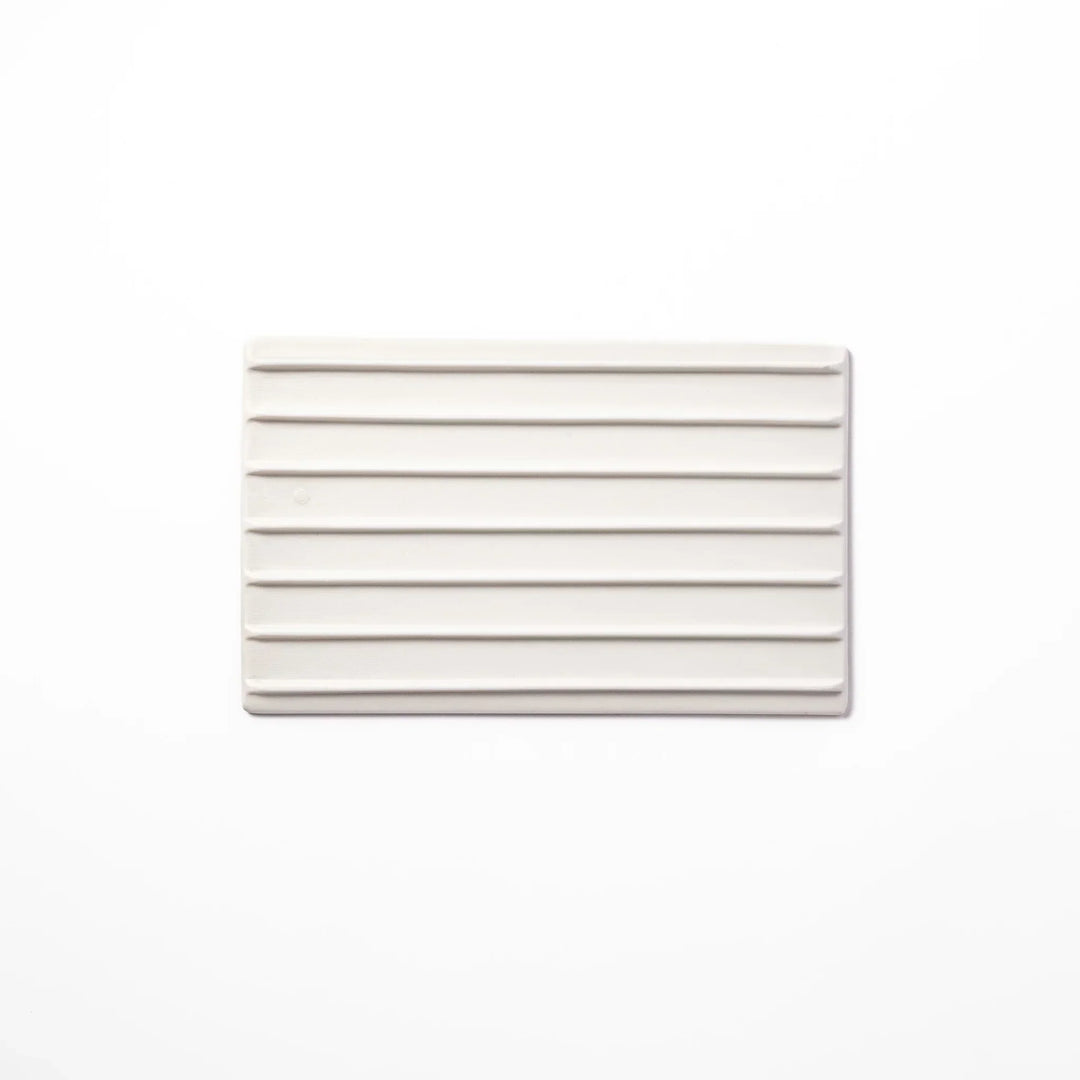 White Japanese ceramic dinner plate with ridged texture and matte gloss contrast for refined elegant dining.