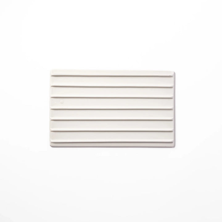 White Japanese ceramic dinner plate with ridged texture and matte gloss contrast for refined elegant dining.