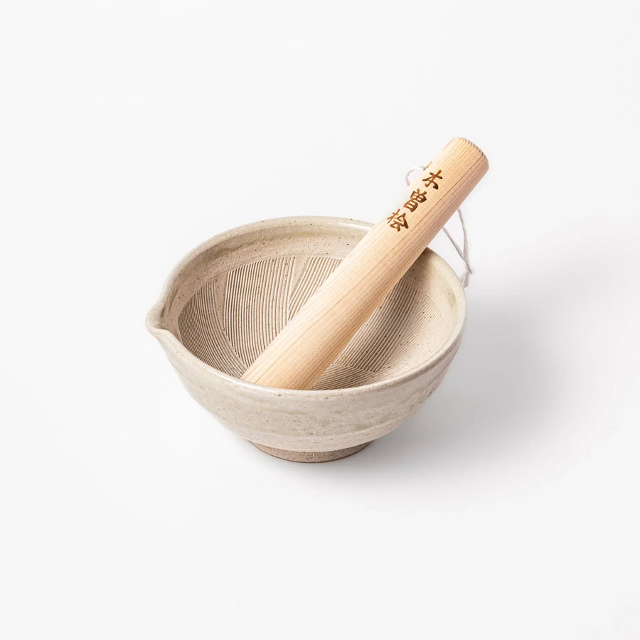 Soft sage Hiwa-glazed mortar with a smooth hinoki wood pestle, perfect for grinding sesame seeds and spices with ease.