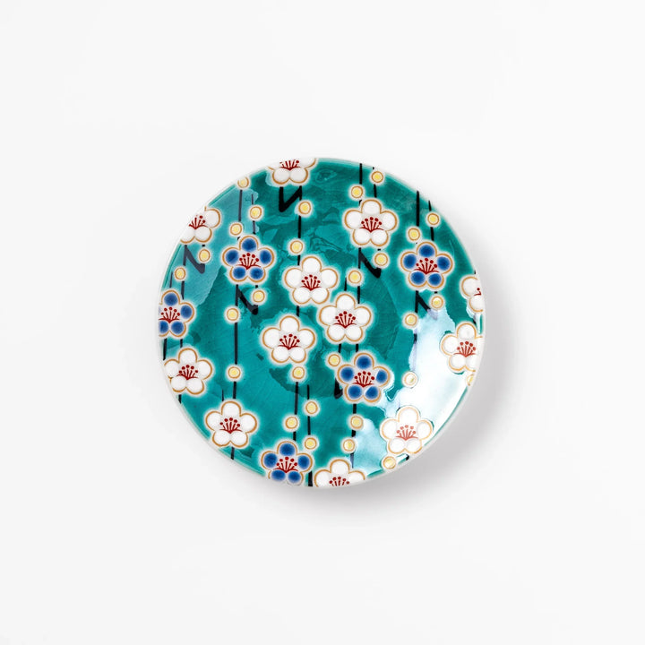 Round Japanese ceramic sauce dish with teal background and white blue plum blossom motifs for condiments.