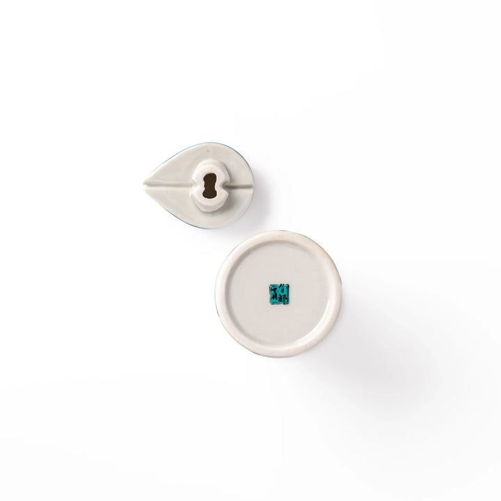 Japanese ceramic soy sauce dispenser with teal lid and yellow body with white plum blossoms made in Arita.