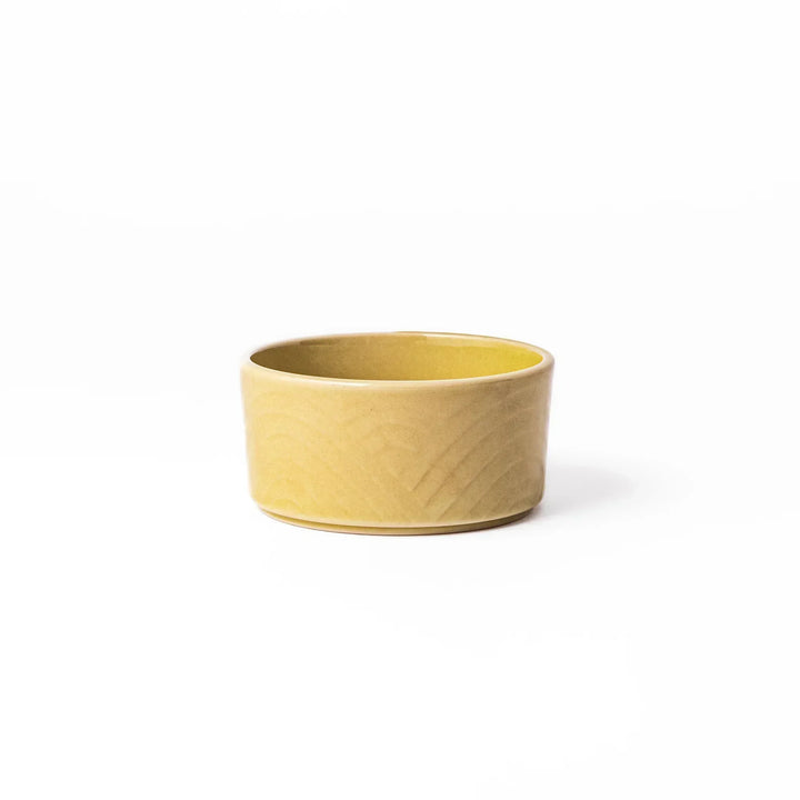 Yellow Japanese porcelain bowl with embossed Seigaiha wave pattern smooth matte glaze and modern design.