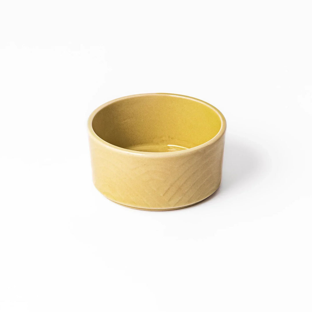 Yellow Japanese porcelain bowl with embossed Seigaiha wave pattern smooth matte glaze and modern design.