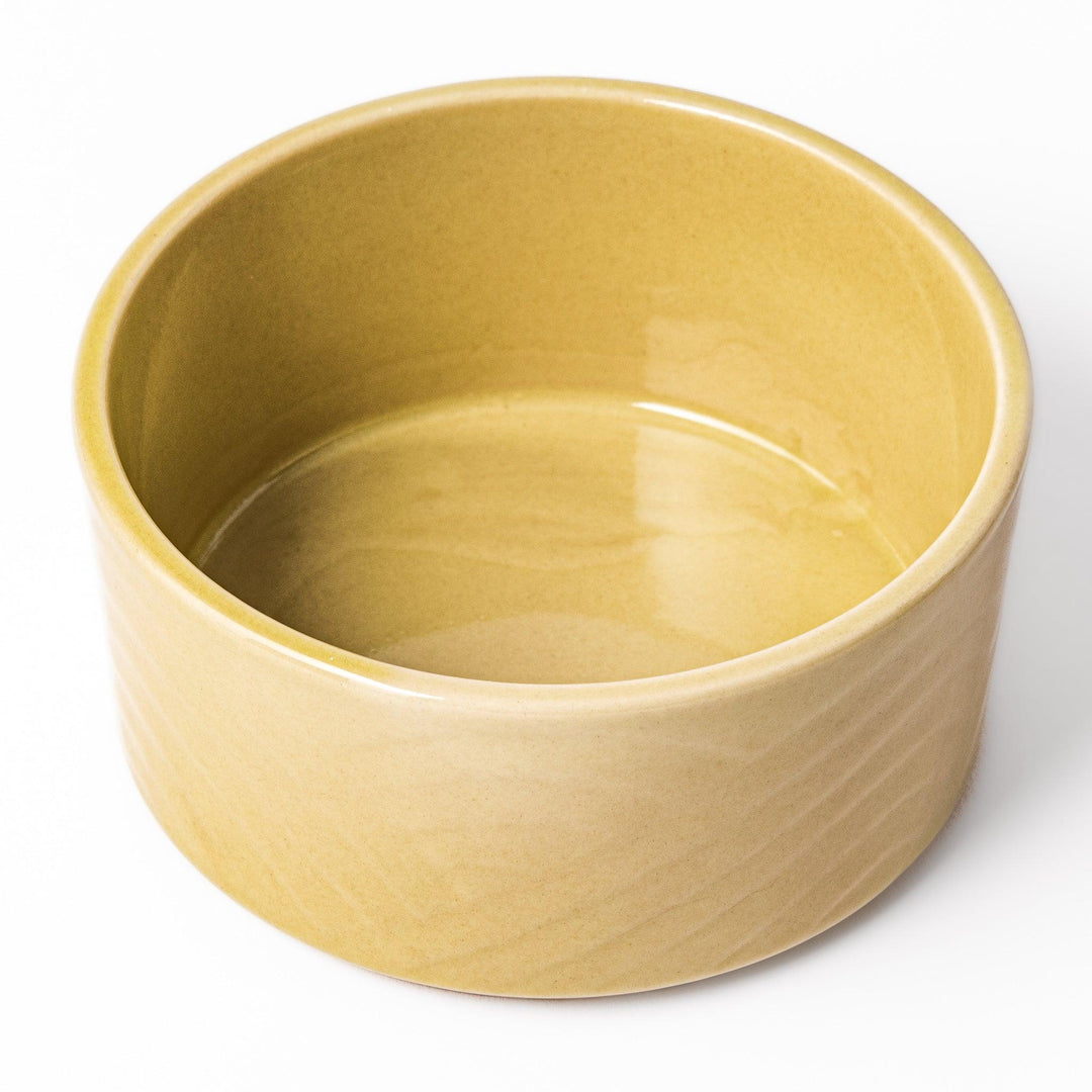 Yellow Japanese porcelain bowl with embossed Seigaiha wave pattern smooth matte glaze and modern design.