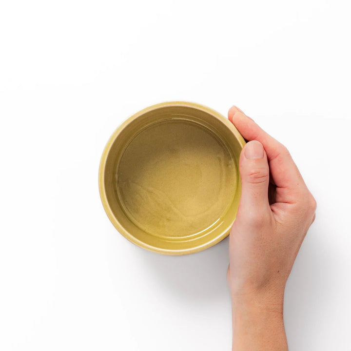 Yellow Japanese porcelain bowl with embossed Seigaiha wave pattern smooth matte glaze and modern design.